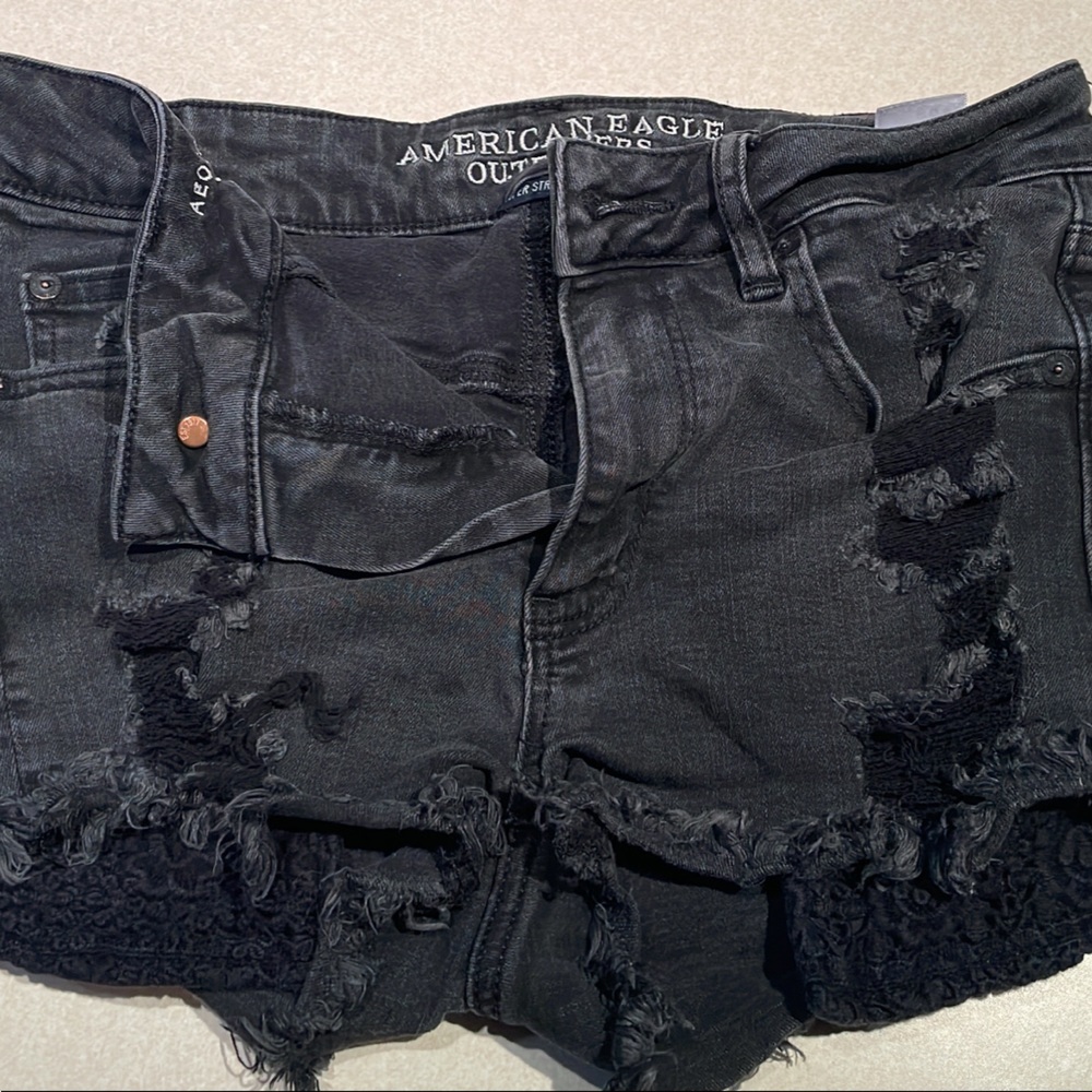 Ripped, black American eagle shorts.